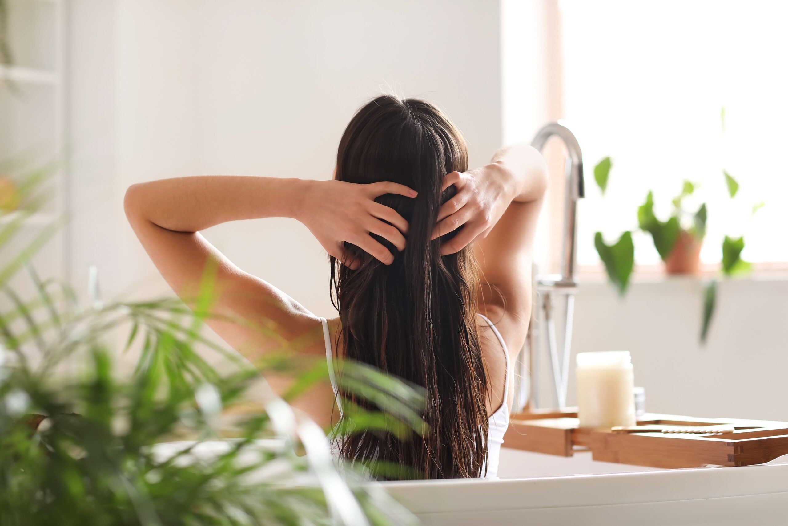 Eine Frau wäscht ihre Haare in der Badewanne