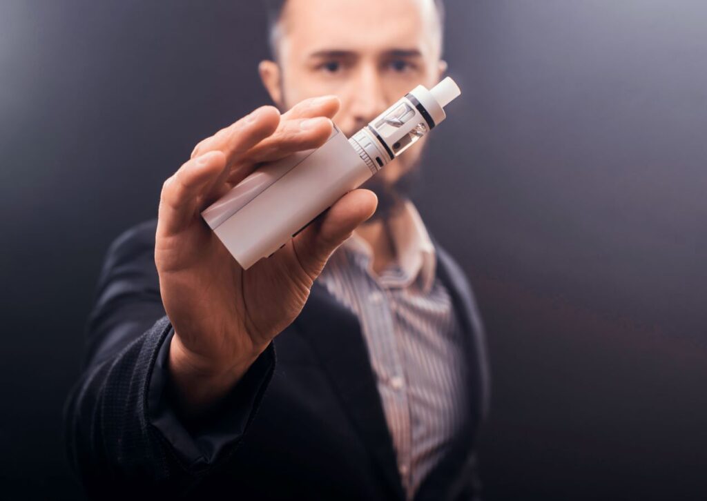 Moderner Vaporizer für Kräuter, elegant präsentiert von einem Mann in Business-Kleidung.