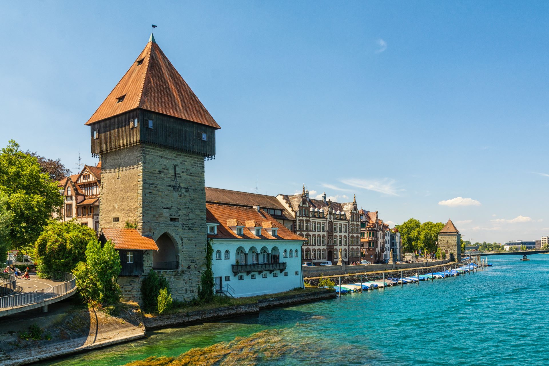 Malerische Altstadt von Konstanz am Bodensee mit historischem Turm und blauem Wasser im Vordergrund.